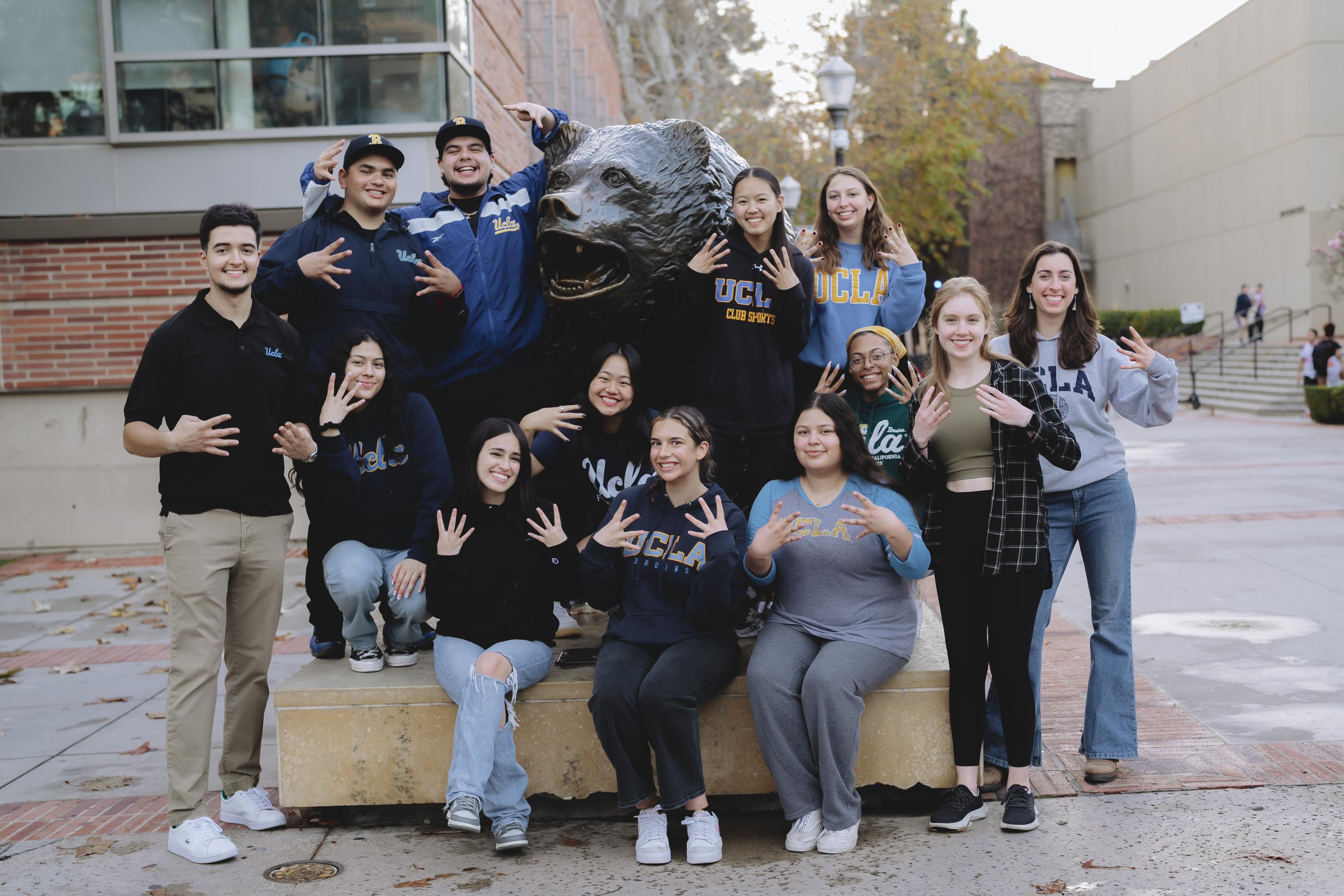 students smiling around the bruin bear
