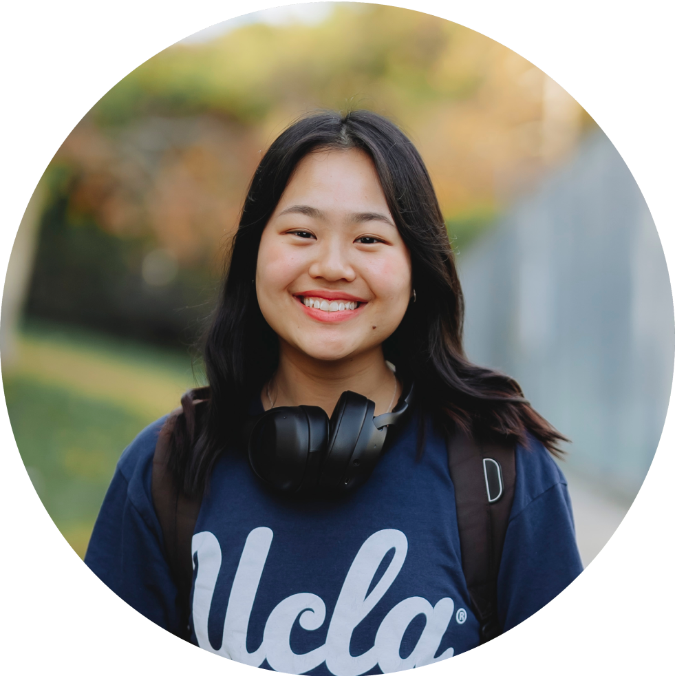 Student wearing headphones around neck smiling