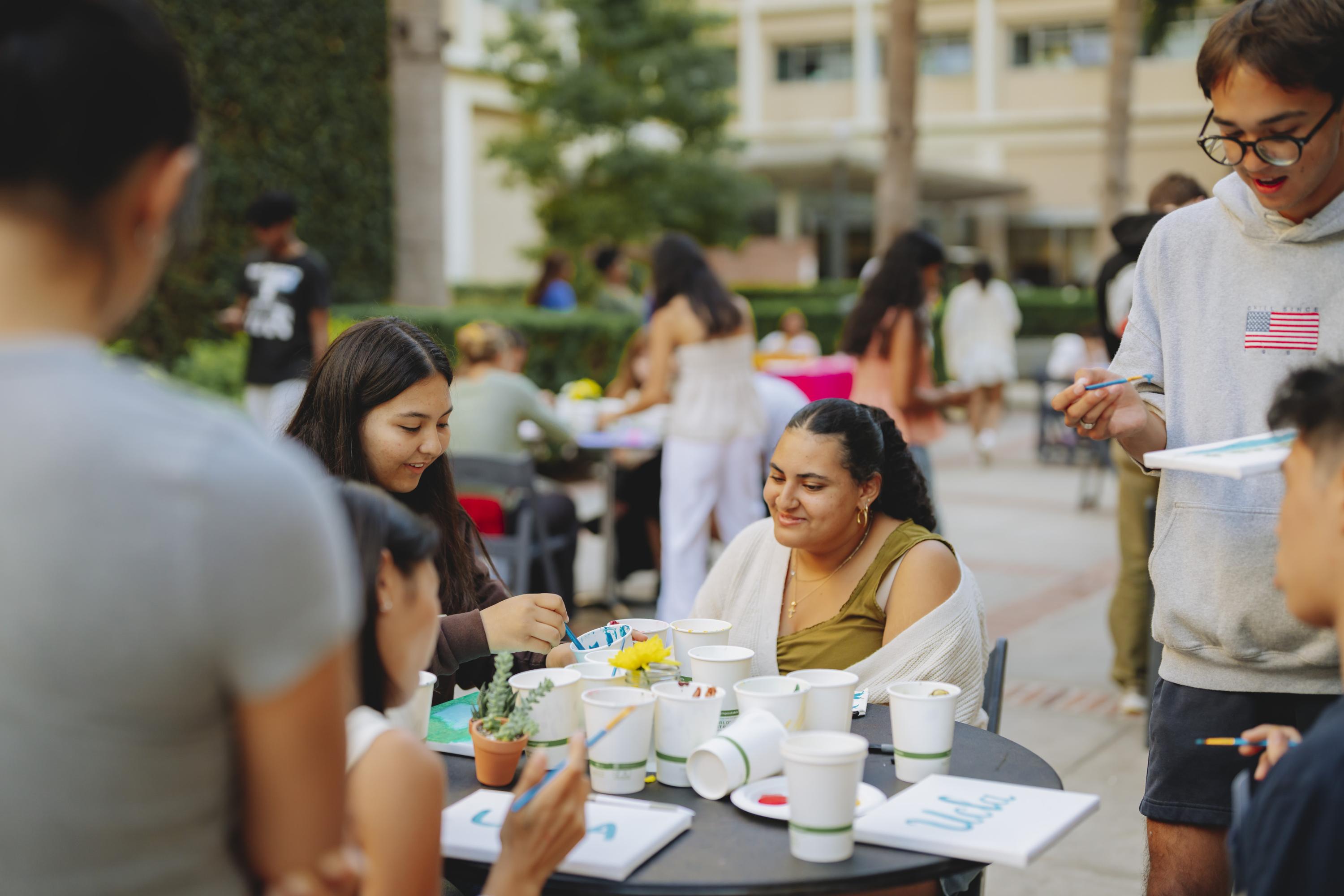Students doing crafts around an outdoor table.