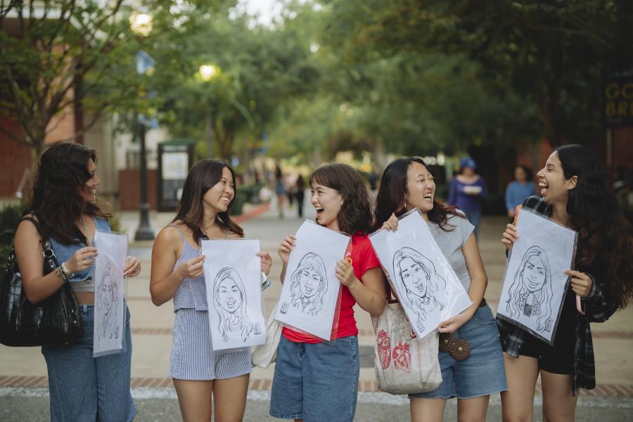Photo of students holding caricatures.
